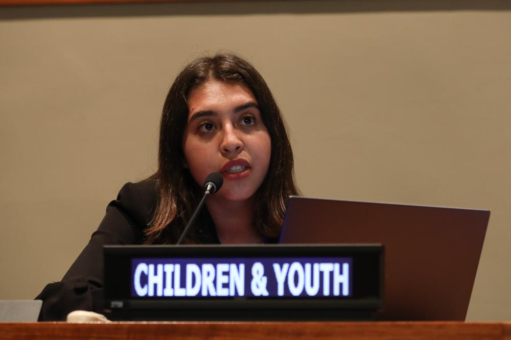 A children & youth representative delivering an intervention at the UN. She looks determined.